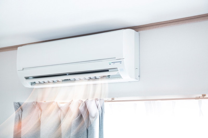 Blog Title: Why Ductless Is the Way to Go Blog Photo: Mounted ductless system above a window