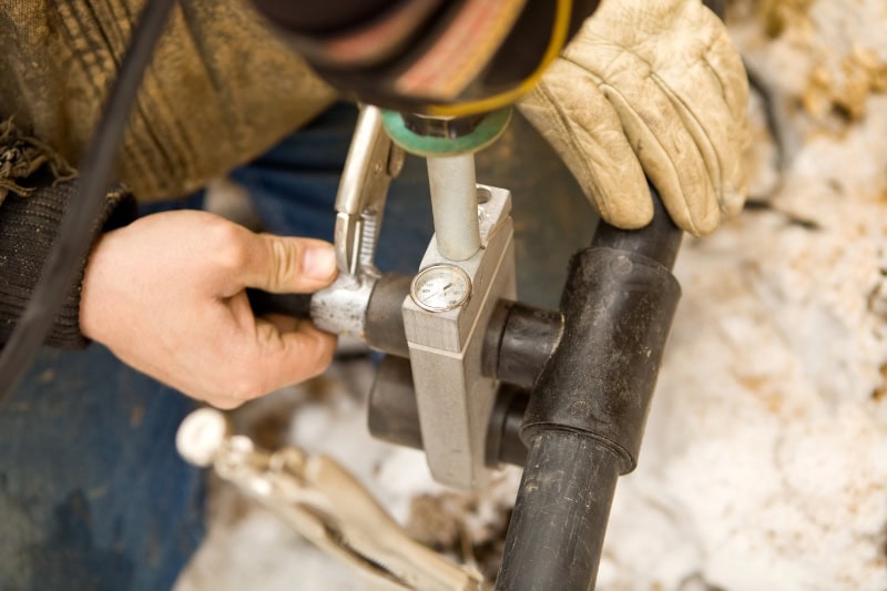 Two Workers Join Residential Geothermal Heating and Cooling Pipe.